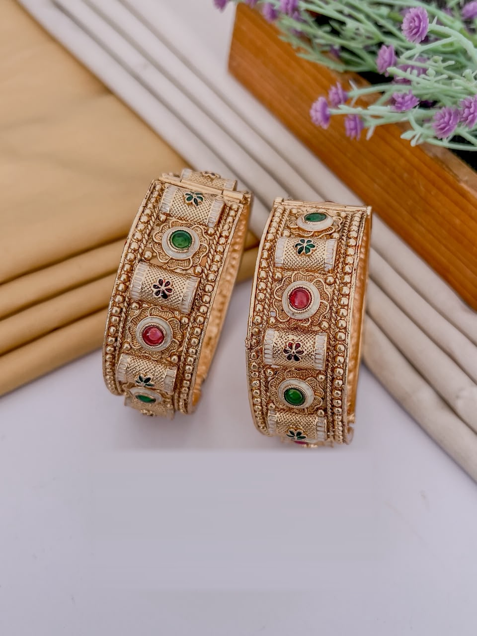 Alternating ruby and emerald gold tone openable bangle pair